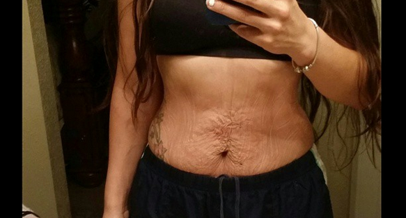 Kvinna tar en selfie i spegeln på sin mage Magselfie
